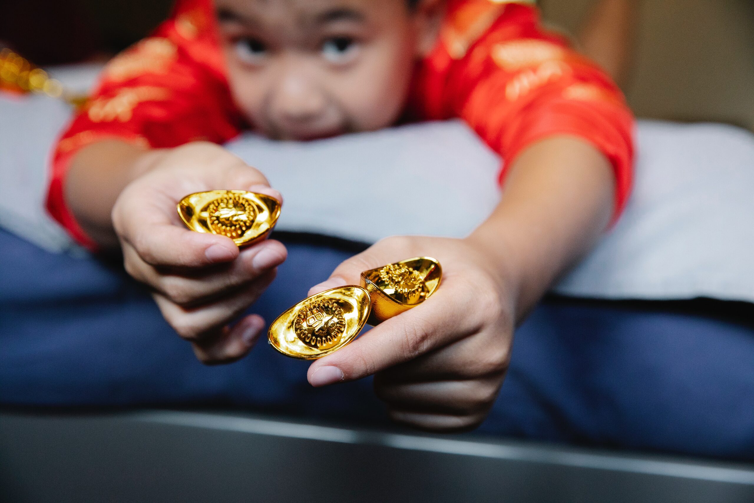 A child holds a pair of gold ingots