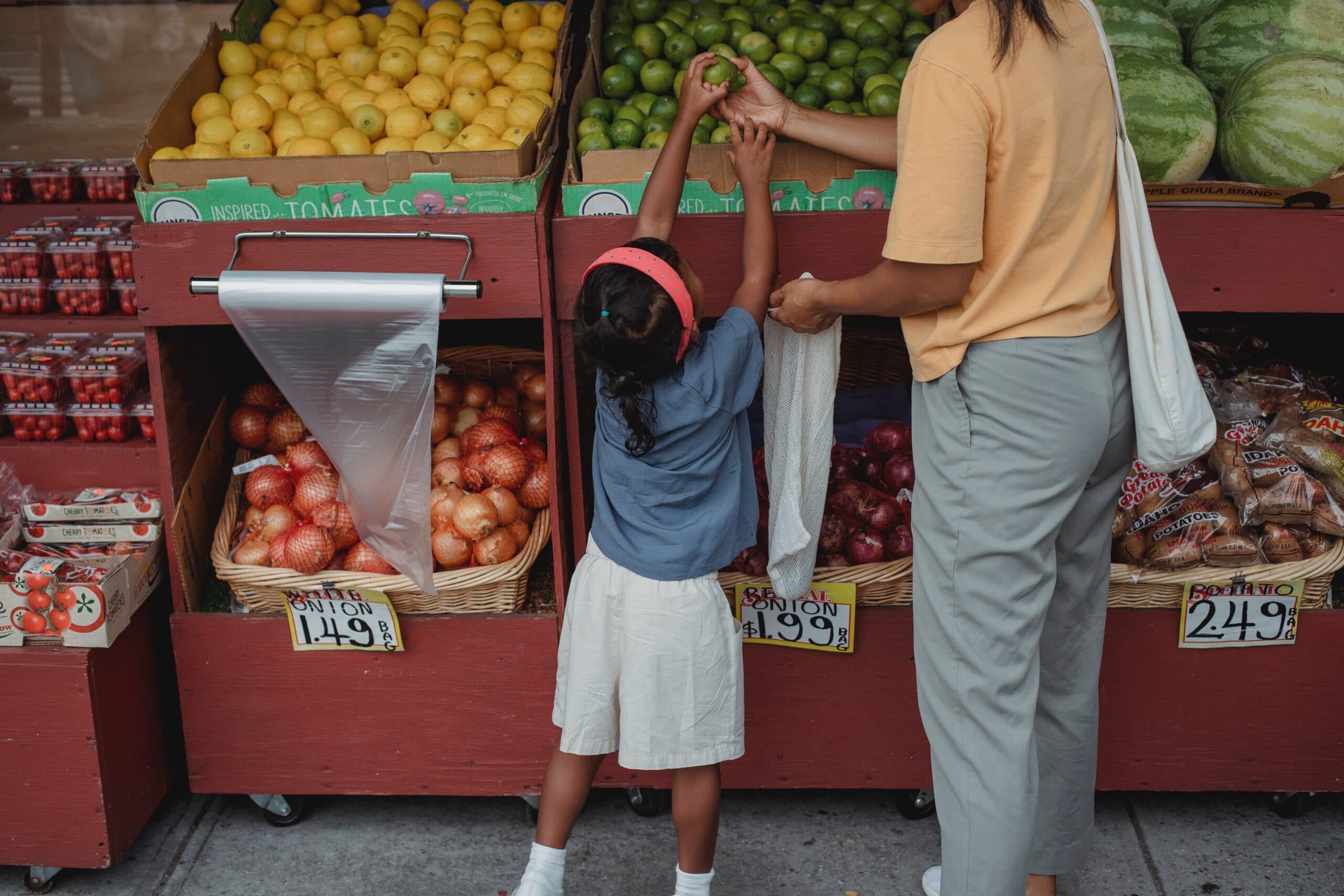 A mother and her daughter are choosing fruits