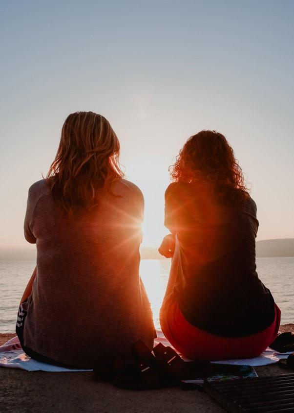 Two people sitting together watching the sunset