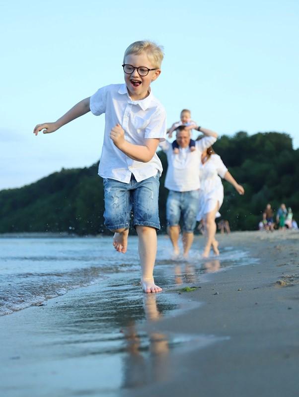 Family running toward the camera on a beach