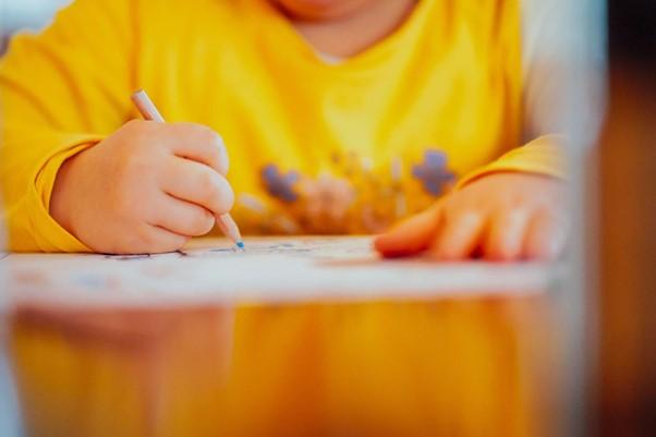 Child drawing picture using a pencil