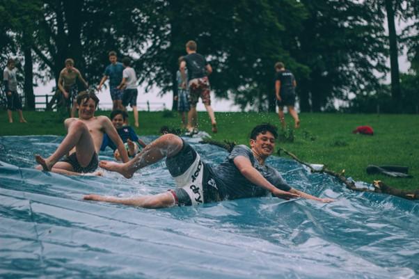 Teens playing on backyard waterslide