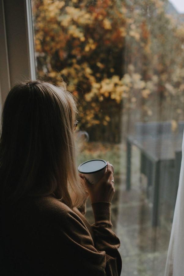 Woman drinking coffee looking out of a window